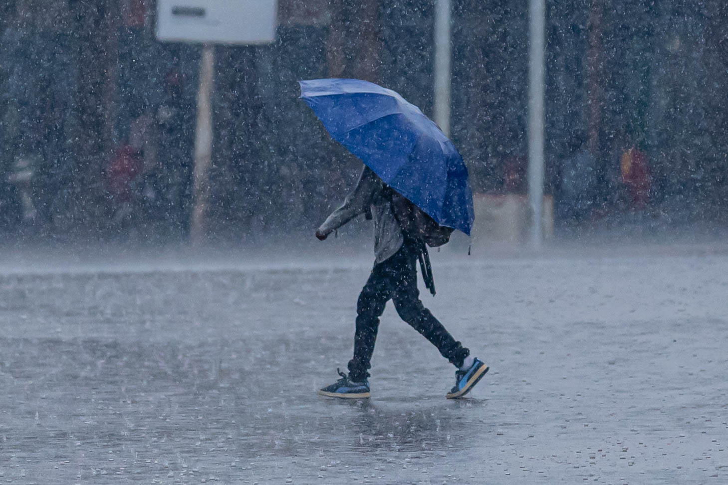 A man walks through heavy rain